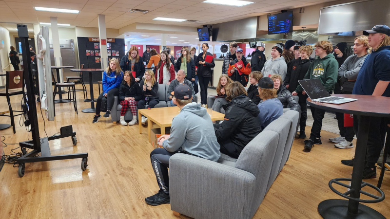 Large group of students looking at TV